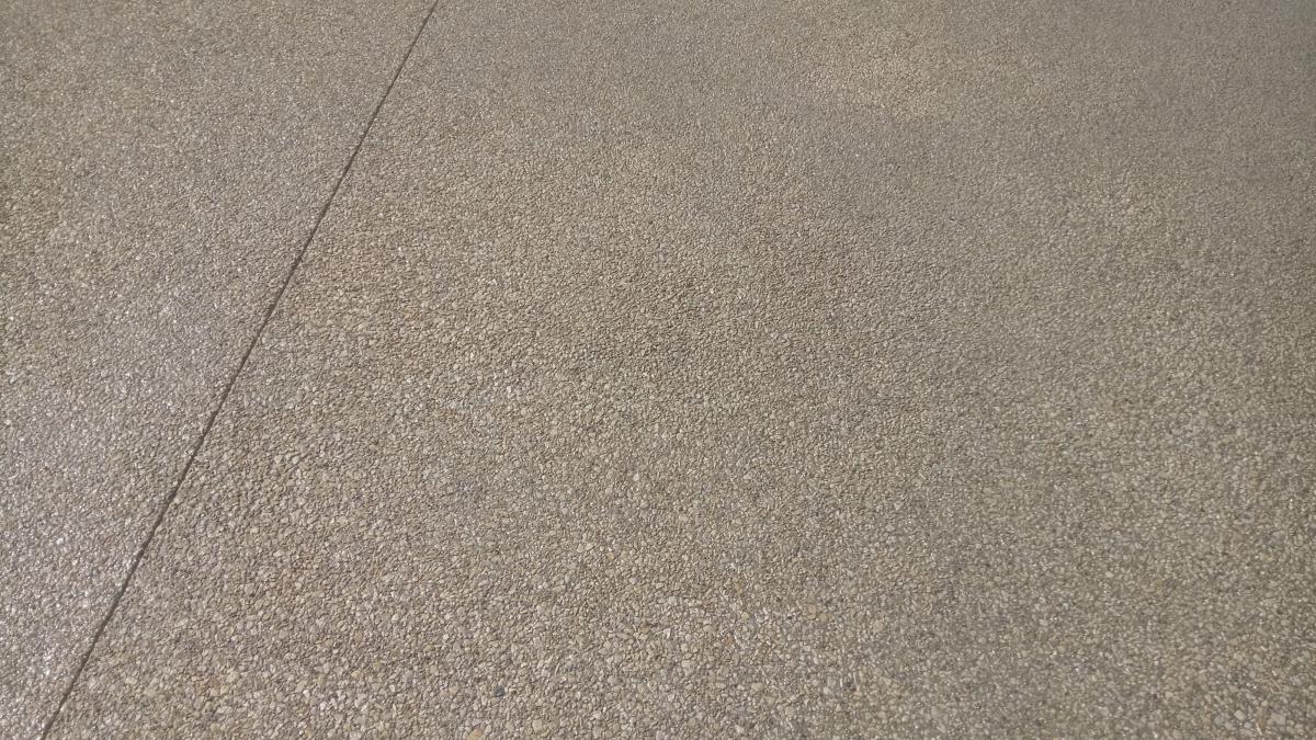 Béton désactivé avec trait de scie de joint de dilatation. Vue de près. Couleur du béton désactivé : ton jaune ocre, brun, chaud.  Béton désactivé avec trait de scie de joint de dilatation. Vue de près. Couleur du béton désactivé : ton jaune ocre, brun, chaud.