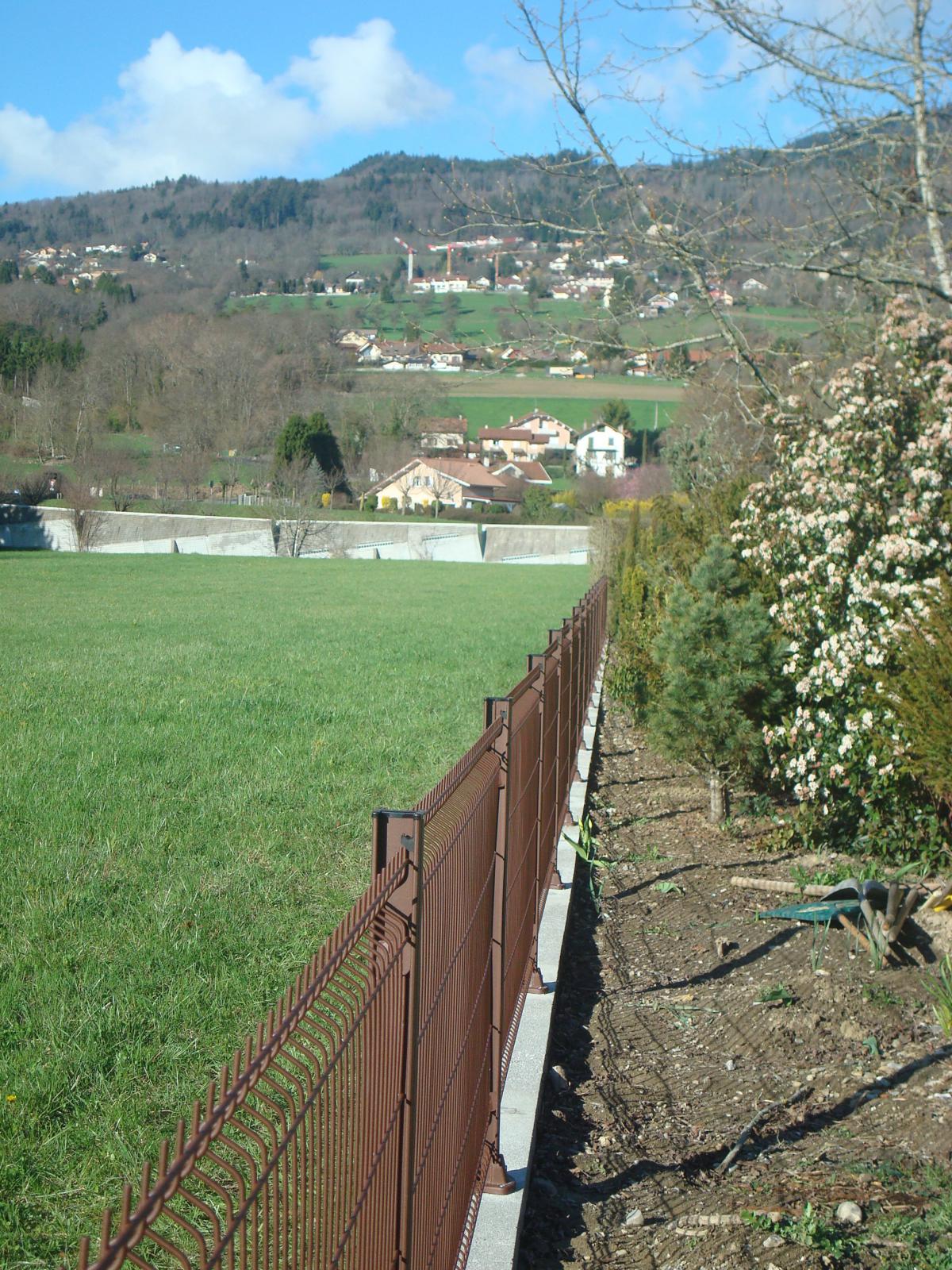 Clôture en panneaux rigides, posés sur un muret en béton. Création paysagiste Annemasse. Clôture en panneaux rigides, posés sur un muret en béton. Création paysagiste Annemasse.