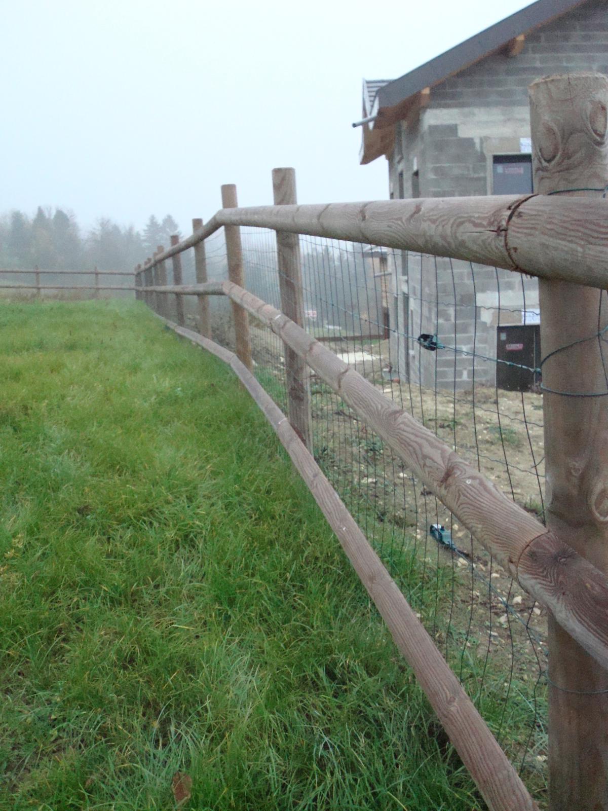 Clôture type ranch en bois pour l'effet visuel, clôture en grillage souple intégré pour que les chiens de la famille ne s'échappent pas. 